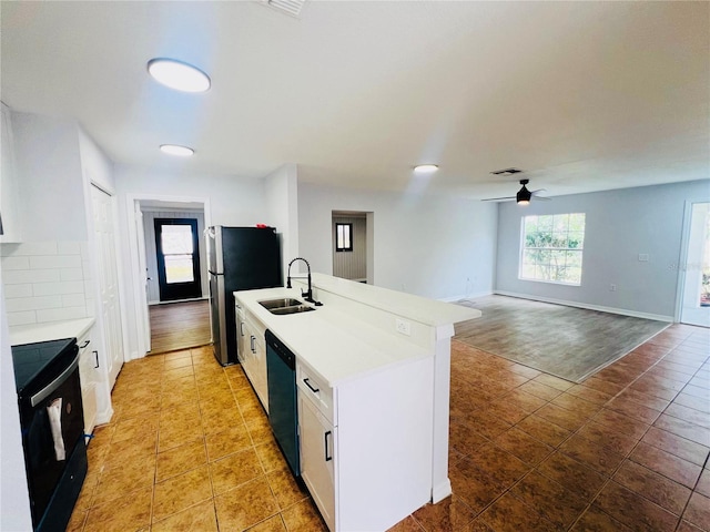 kitchen featuring black appliances, white cabinets, a center island with sink, sink, and ceiling fan