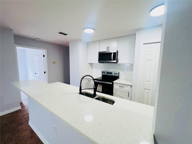 kitchen featuring backsplash, sink, white cabinets, and stainless steel appliances