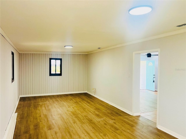 spare room with hardwood / wood-style floors and crown molding