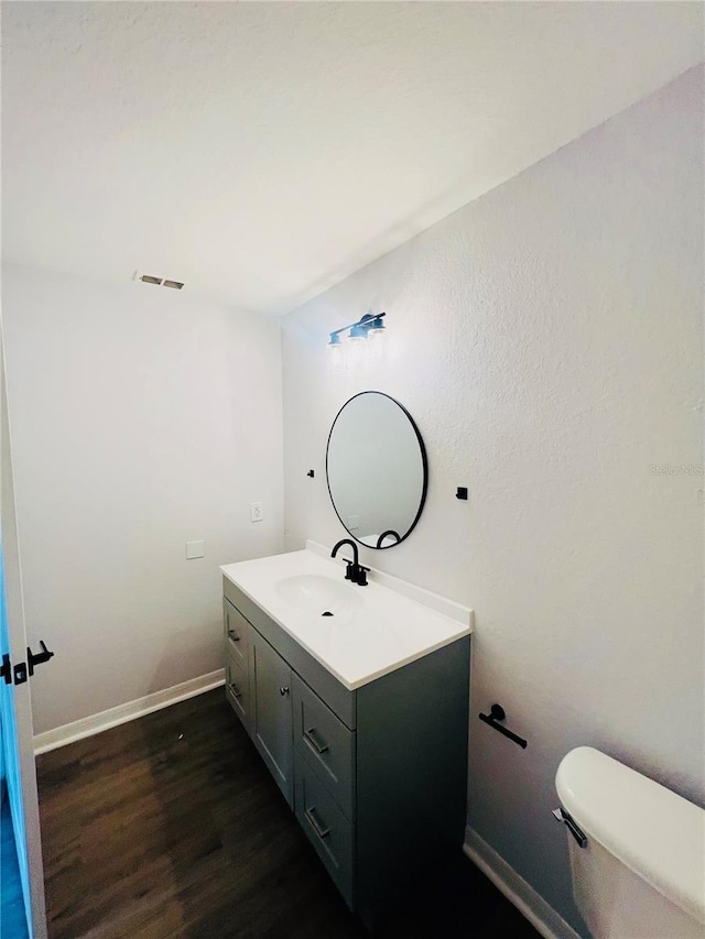 bathroom featuring hardwood / wood-style flooring, vanity, and toilet