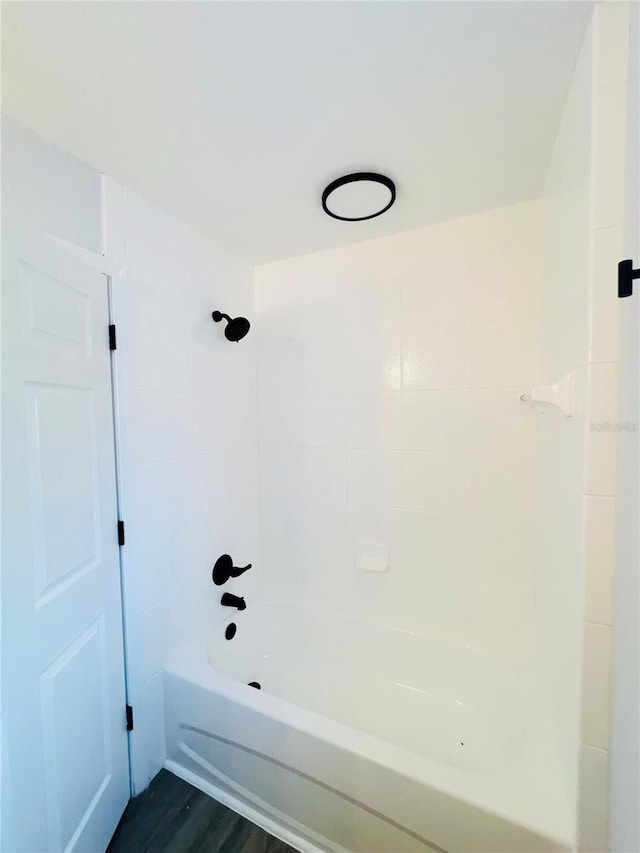 bathroom with hardwood / wood-style floors and tiled shower / bath combo