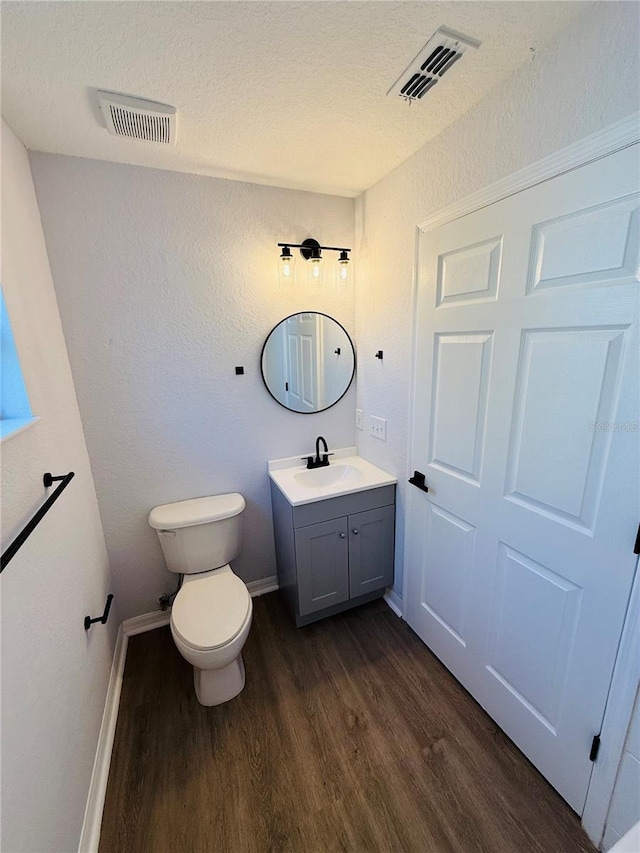 bathroom featuring hardwood / wood-style floors, vanity, a textured ceiling, and toilet