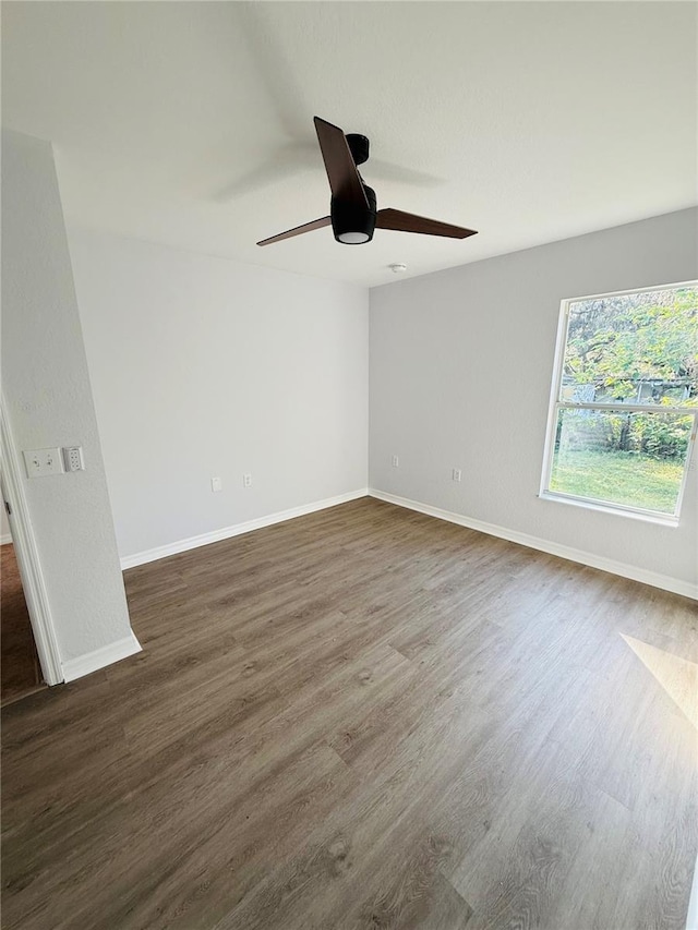 spare room with dark hardwood / wood-style floors and ceiling fan