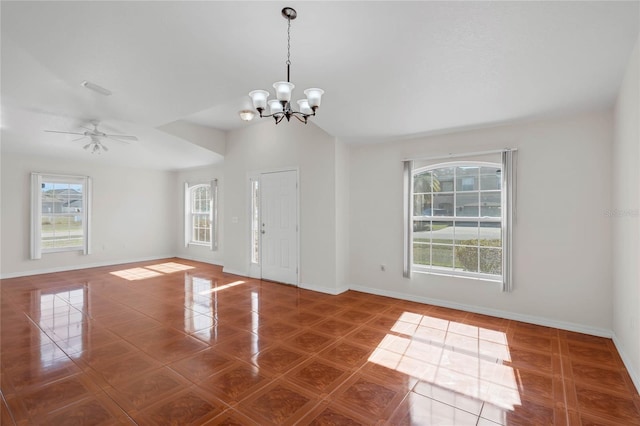 tiled empty room featuring vaulted ceiling and ceiling fan with notable chandelier