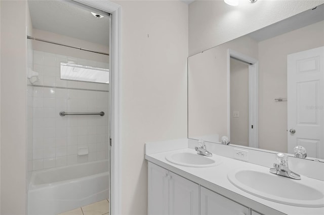 bathroom featuring tile patterned flooring, vanity, and tiled shower / bath