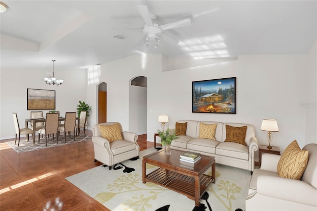 tiled living room with ceiling fan with notable chandelier and vaulted ceiling