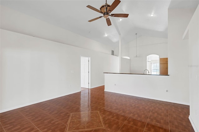 spare room with ceiling fan, high vaulted ceiling, and dark tile patterned flooring