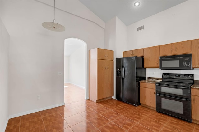 kitchen with black appliances, tile patterned floors, and high vaulted ceiling