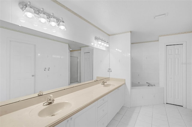 bathroom with tile patterned flooring, vanity, and tiled tub