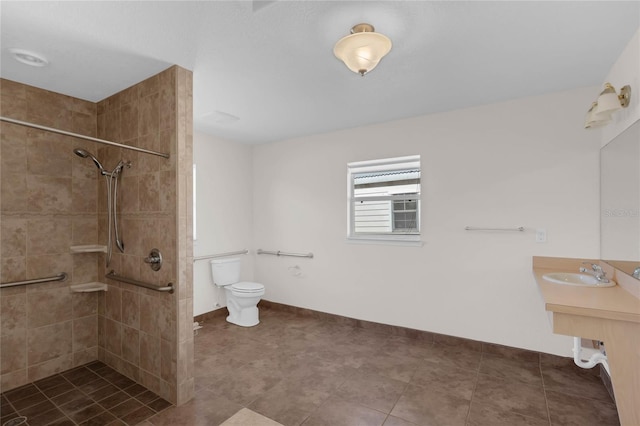 bathroom featuring tiled shower, sink, and toilet