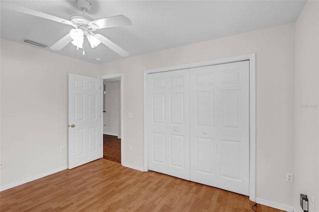 unfurnished bedroom featuring ceiling fan, light hardwood / wood-style floors, and a closet