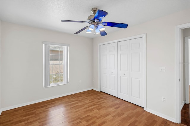 unfurnished bedroom featuring hardwood / wood-style flooring, ceiling fan, a textured ceiling, and a closet