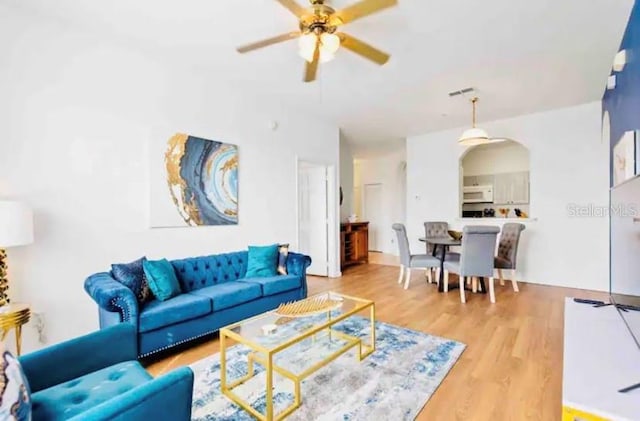 living room featuring ceiling fan and hardwood / wood-style floors