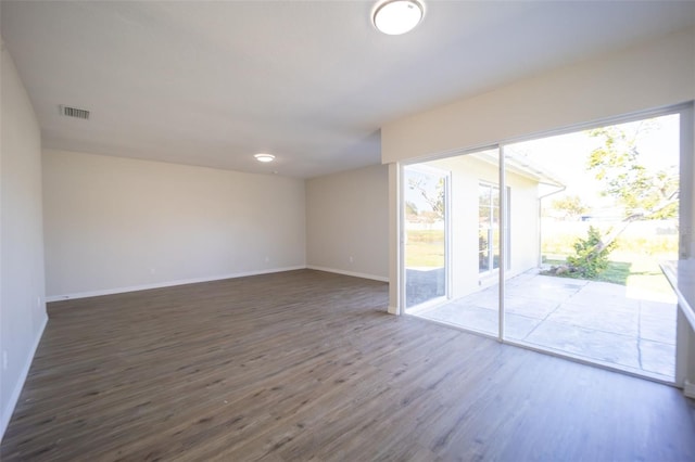 spare room featuring dark hardwood / wood-style flooring and a healthy amount of sunlight