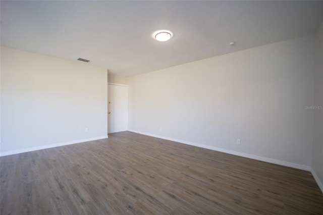 spare room with dark hardwood / wood-style flooring