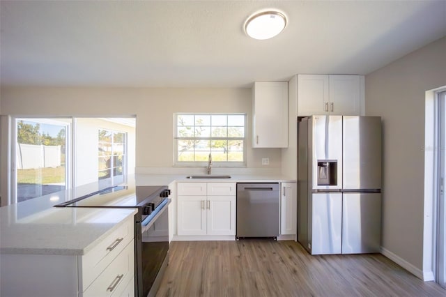 kitchen featuring a healthy amount of sunlight, white cabinetry, and stainless steel appliances