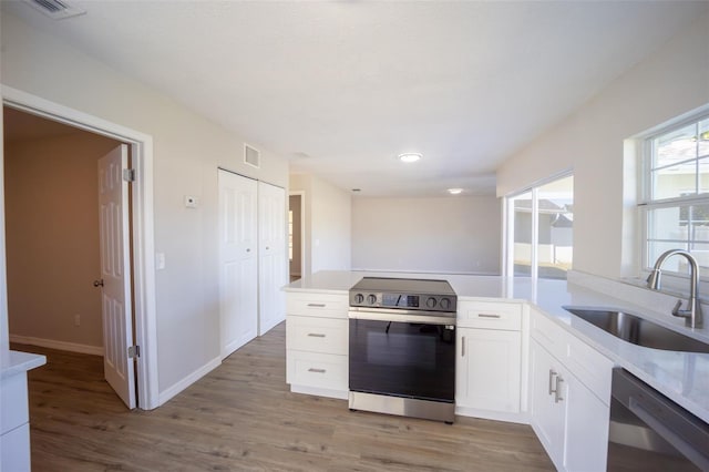 kitchen with white cabinets, hardwood / wood-style flooring, sink, and appliances with stainless steel finishes