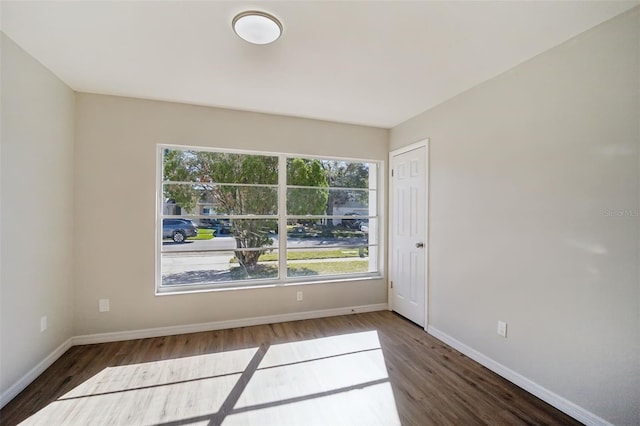 unfurnished room with dark hardwood / wood-style flooring