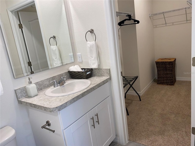 310 Gardenia Ct, Poinciana, FL 34759 - bathroom featuring vanity, a spacious closet, and toilet