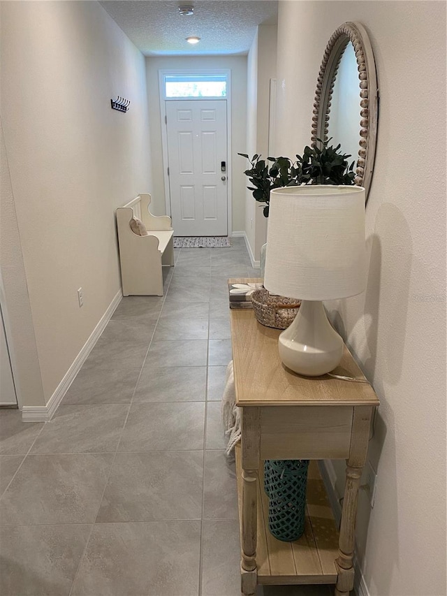310 Gardenia Ct, Poinciana, FL 34759 - foyer with baseboards, a textured ceiling, and light tile patterned flooring