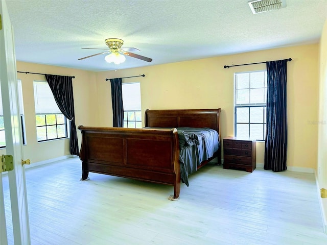 bedroom with ceiling fan, light wood-type flooring, and multiple windows