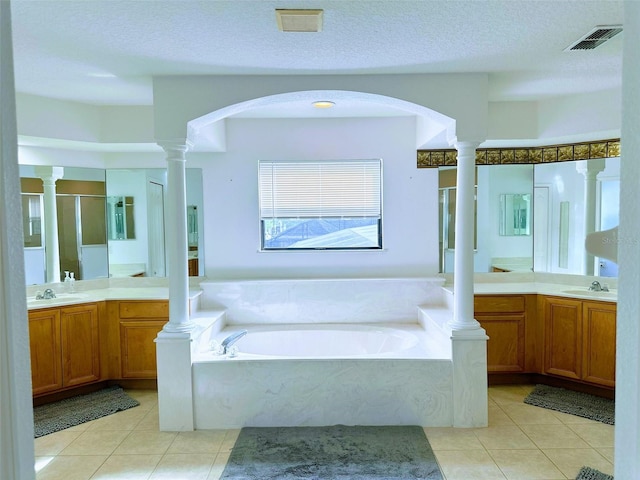 bathroom featuring tile patterned floors, vanity, plus walk in shower, and a textured ceiling