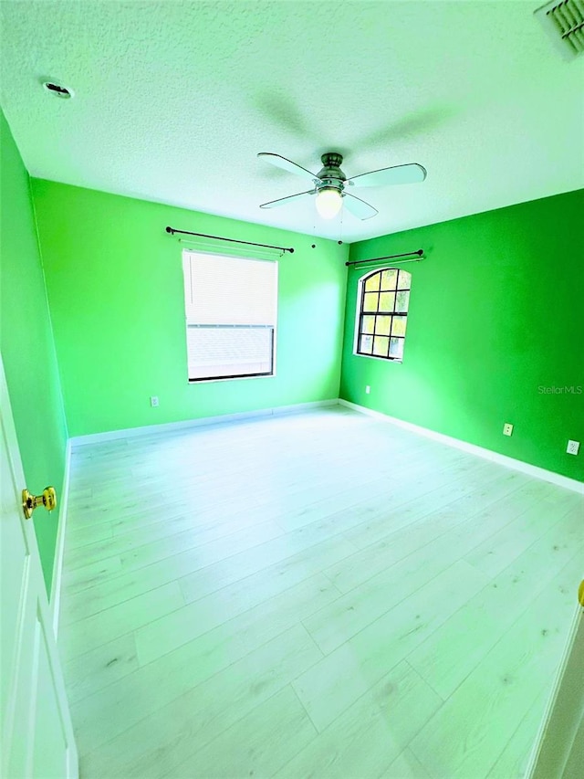 spare room with a textured ceiling, hardwood / wood-style flooring, and ceiling fan