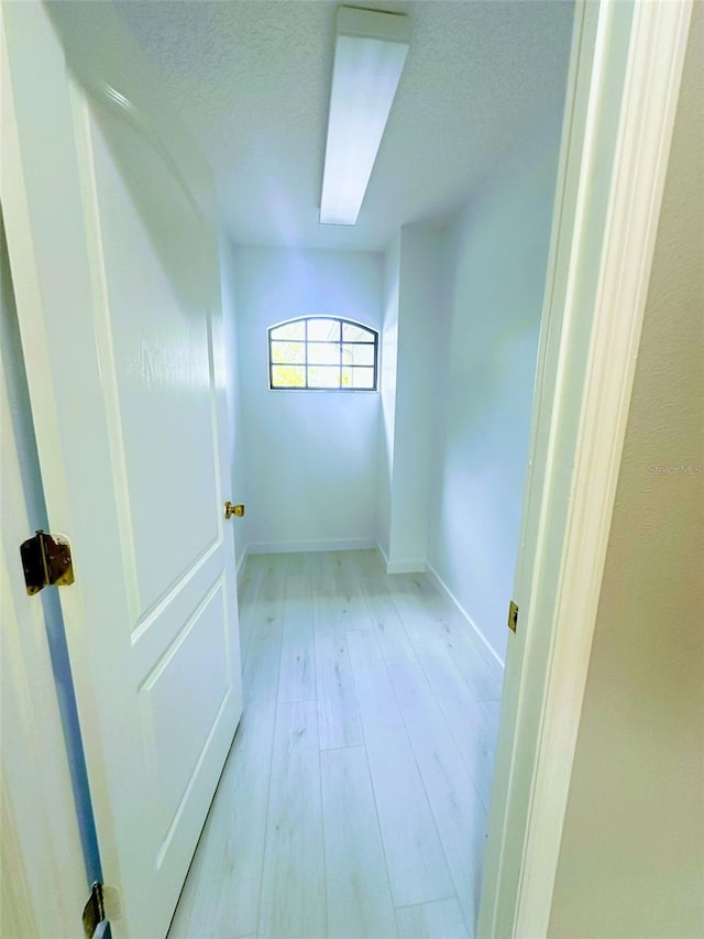 interior space featuring a textured ceiling and light hardwood / wood-style floors