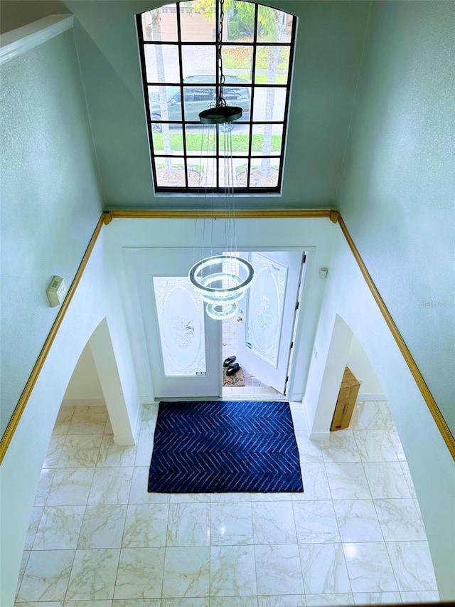 foyer featuring a towering ceiling and crown molding