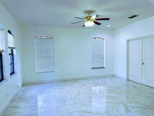 empty room featuring a textured ceiling and ceiling fan