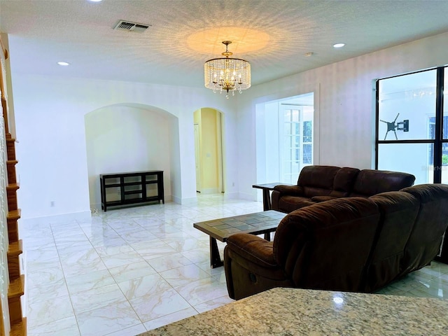 living room featuring a textured ceiling and a notable chandelier