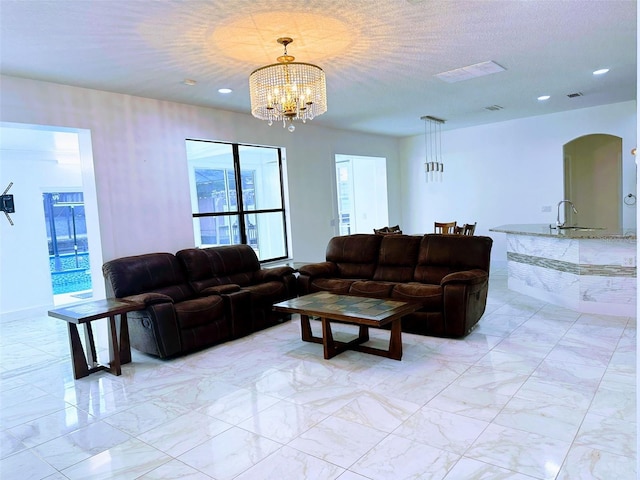 living room with a textured ceiling and a chandelier