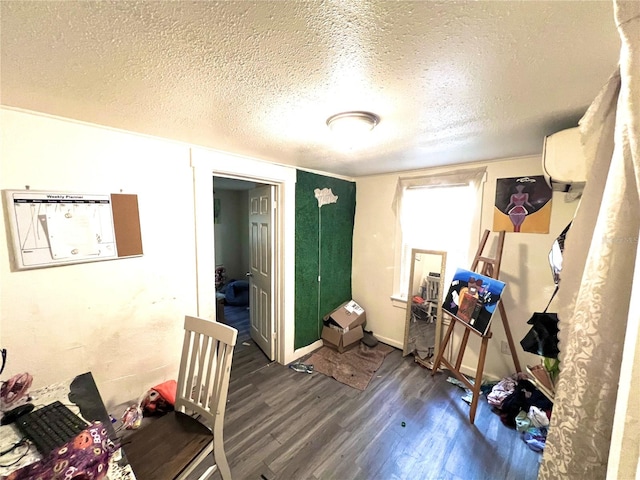 misc room featuring dark hardwood / wood-style flooring, a textured ceiling, and an AC wall unit