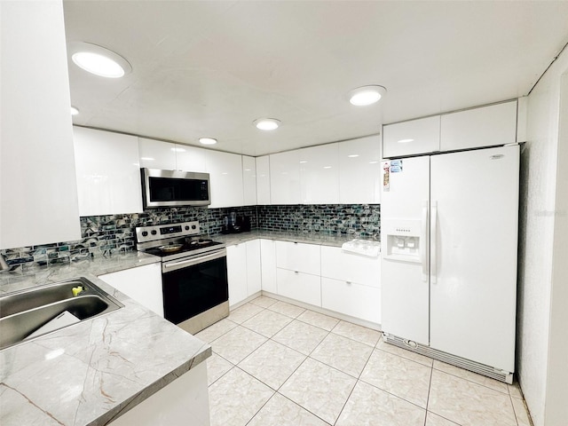 kitchen featuring white cabinets, sink, decorative backsplash, appliances with stainless steel finishes, and light tile patterned flooring