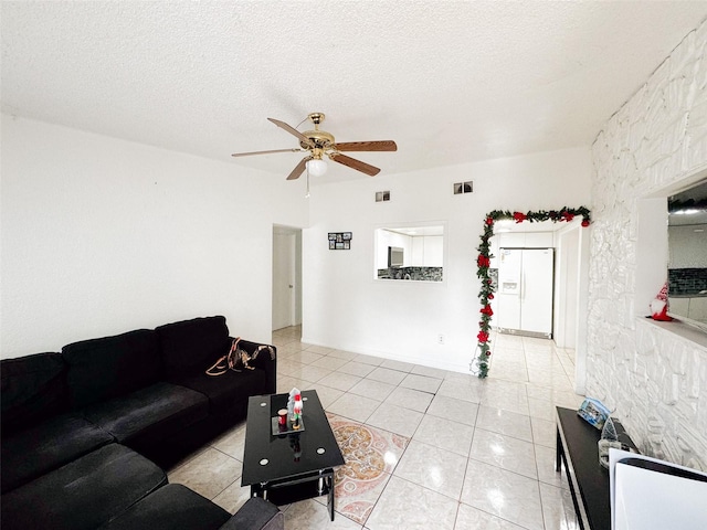 living room with light tile patterned floors, a textured ceiling, and ceiling fan