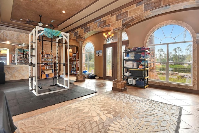 exercise area featuring tile patterned flooring, decorative columns, a wealth of natural light, and ceiling fan