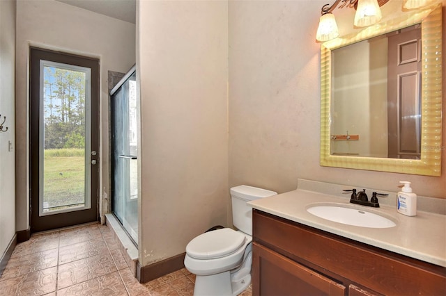 bathroom featuring a shower with door, vanity, and toilet