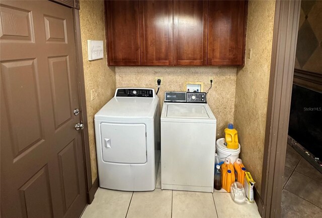 laundry room featuring cabinets, separate washer and dryer, and light tile patterned floors