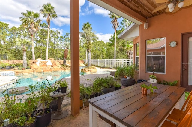 view of patio featuring ceiling fan and a fenced in pool