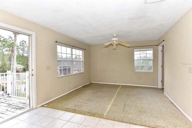 tiled spare room with plenty of natural light and ceiling fan