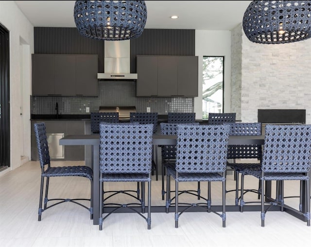 kitchen with tasteful backsplash, a notable chandelier, and ventilation hood