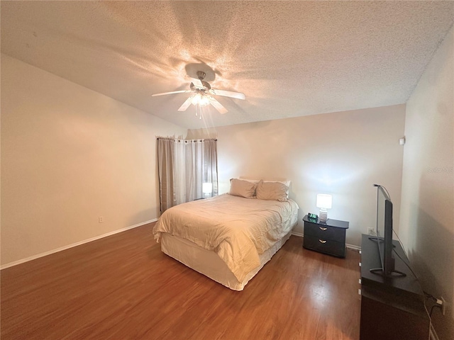 bedroom with a textured ceiling, dark hardwood / wood-style floors, ceiling fan, and lofted ceiling