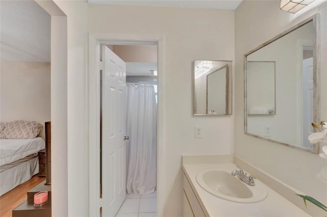 bathroom featuring curtained shower, tile patterned flooring, vanity, and a textured ceiling