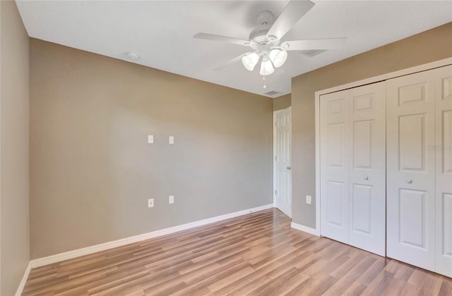 unfurnished bedroom featuring ceiling fan, light wood-type flooring, and a closet