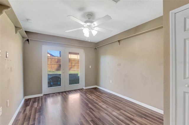 empty room with ceiling fan, french doors, and dark hardwood / wood-style floors