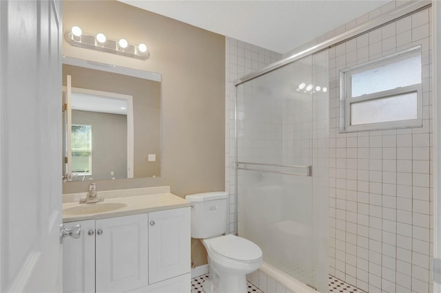 bathroom featuring tile patterned floors, a shower with door, vanity, and toilet