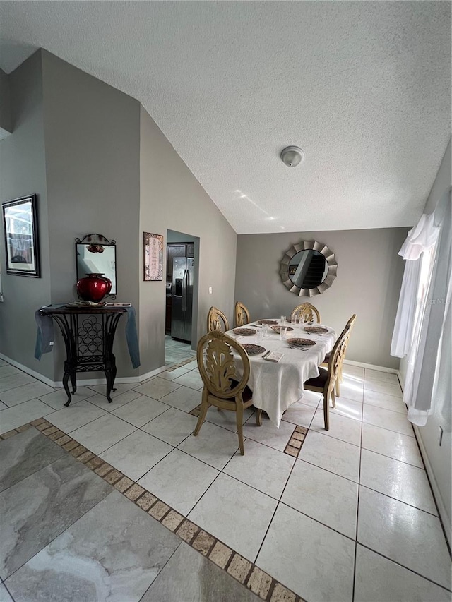 dining area with a textured ceiling and lofted ceiling