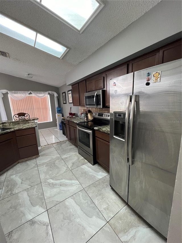 kitchen featuring sink, a textured ceiling, appliances with stainless steel finishes, tasteful backsplash, and dark brown cabinets