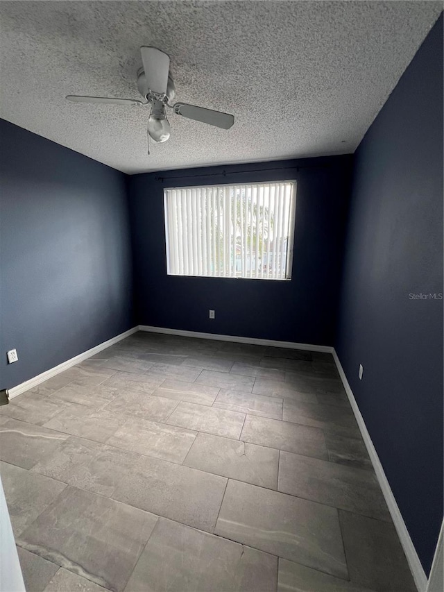 empty room featuring ceiling fan and a textured ceiling