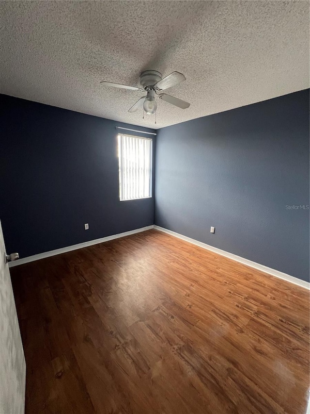 empty room featuring ceiling fan, wood-type flooring, and a textured ceiling